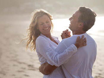 A happy couple on the beach laughing