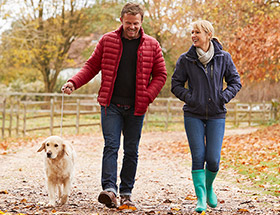 couple walking with dog outside