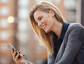 Stunning blonde woman using her smartphone