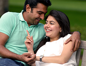 pakistani couple on a park bench laughing