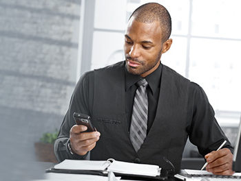 man in suit looking at his phone