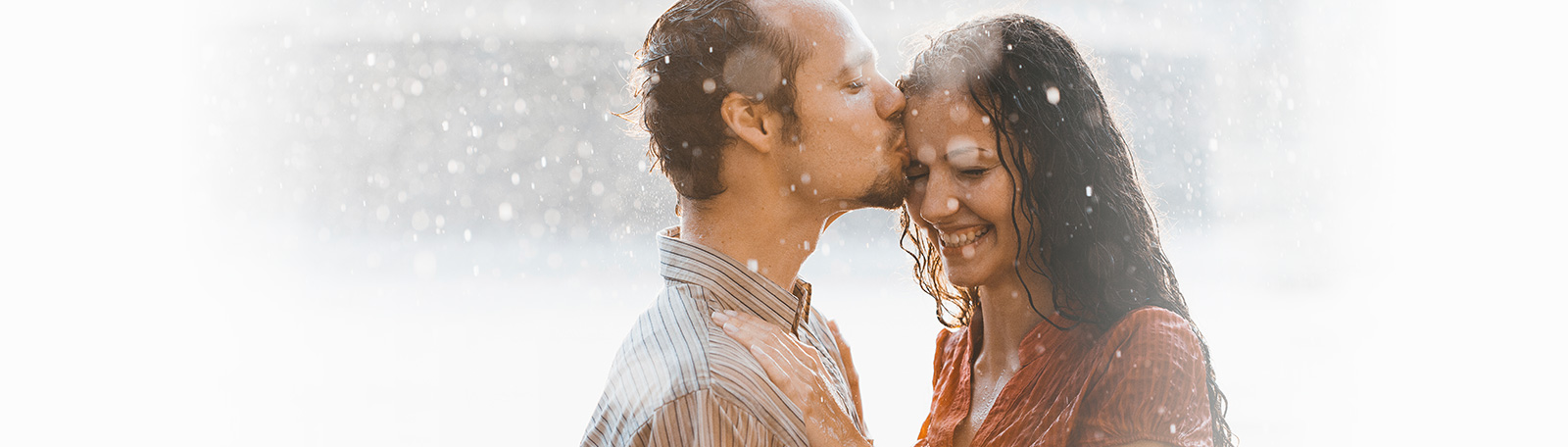 international couple kissing in the rain