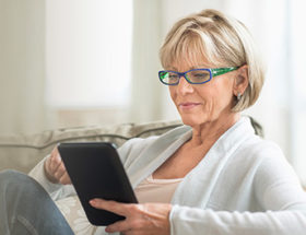 older woman using ipad inside