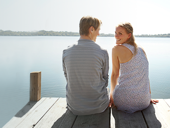 couple sitting together by lake