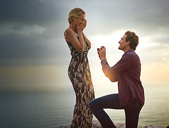 Couple during a proposal at sunset