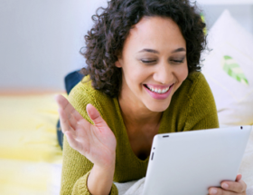 Curly haired woman sending online dating messages from her tablet