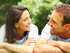 couple smiling at eachother outside