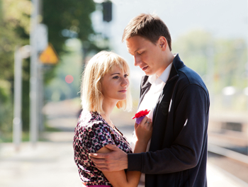 couple holding each other on train platform